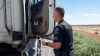An Arizona State Trooper with the Commercial Vehicle Enforcement Task Force Talks to a Trucker Beside the Road
