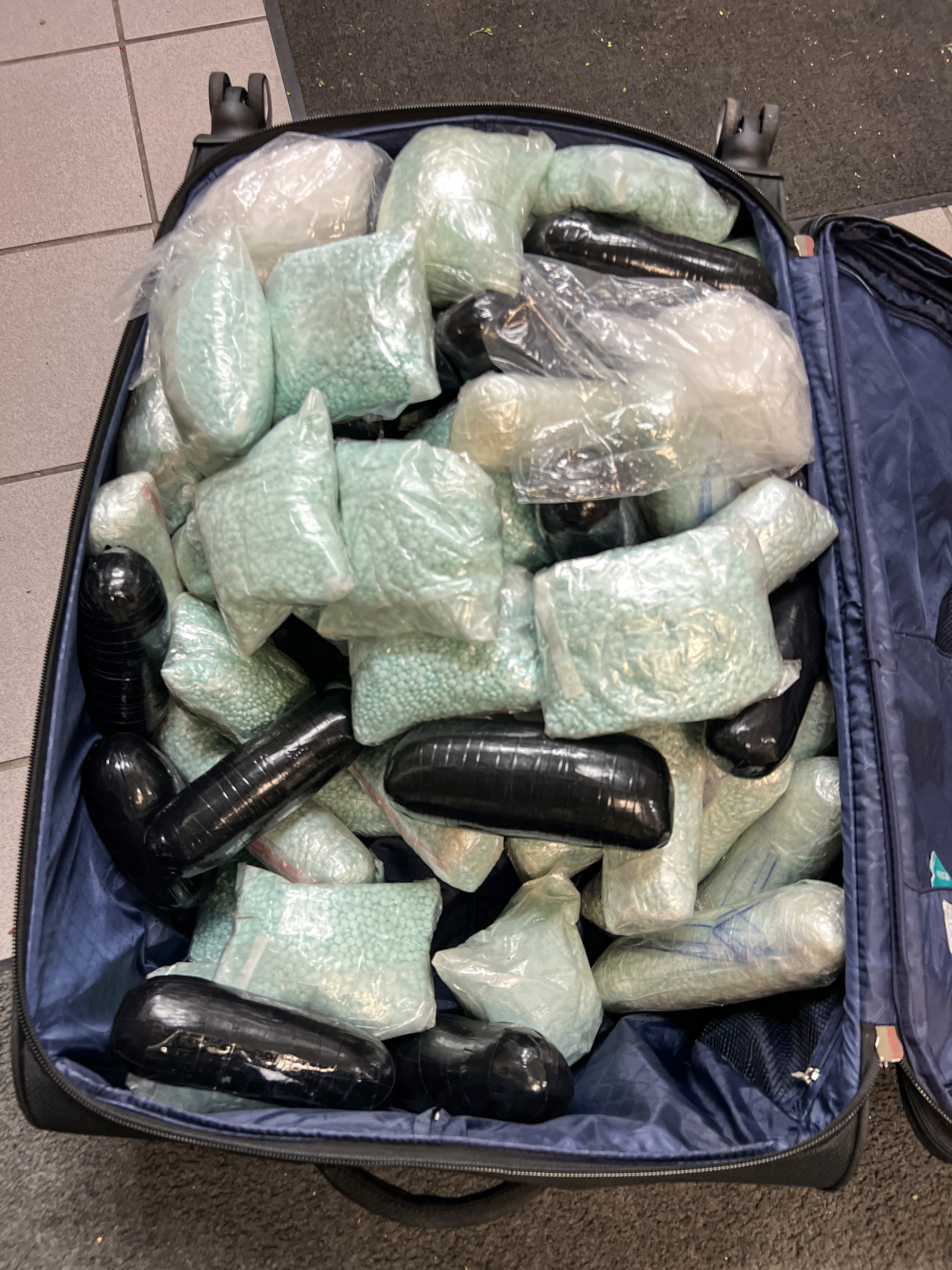 Plastic wrapped bundles of drugs in an open suitcase