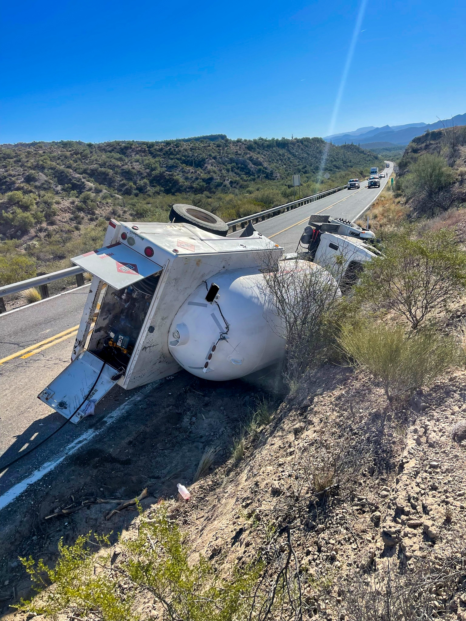 Propane tanker turned over on passenger side next to a road