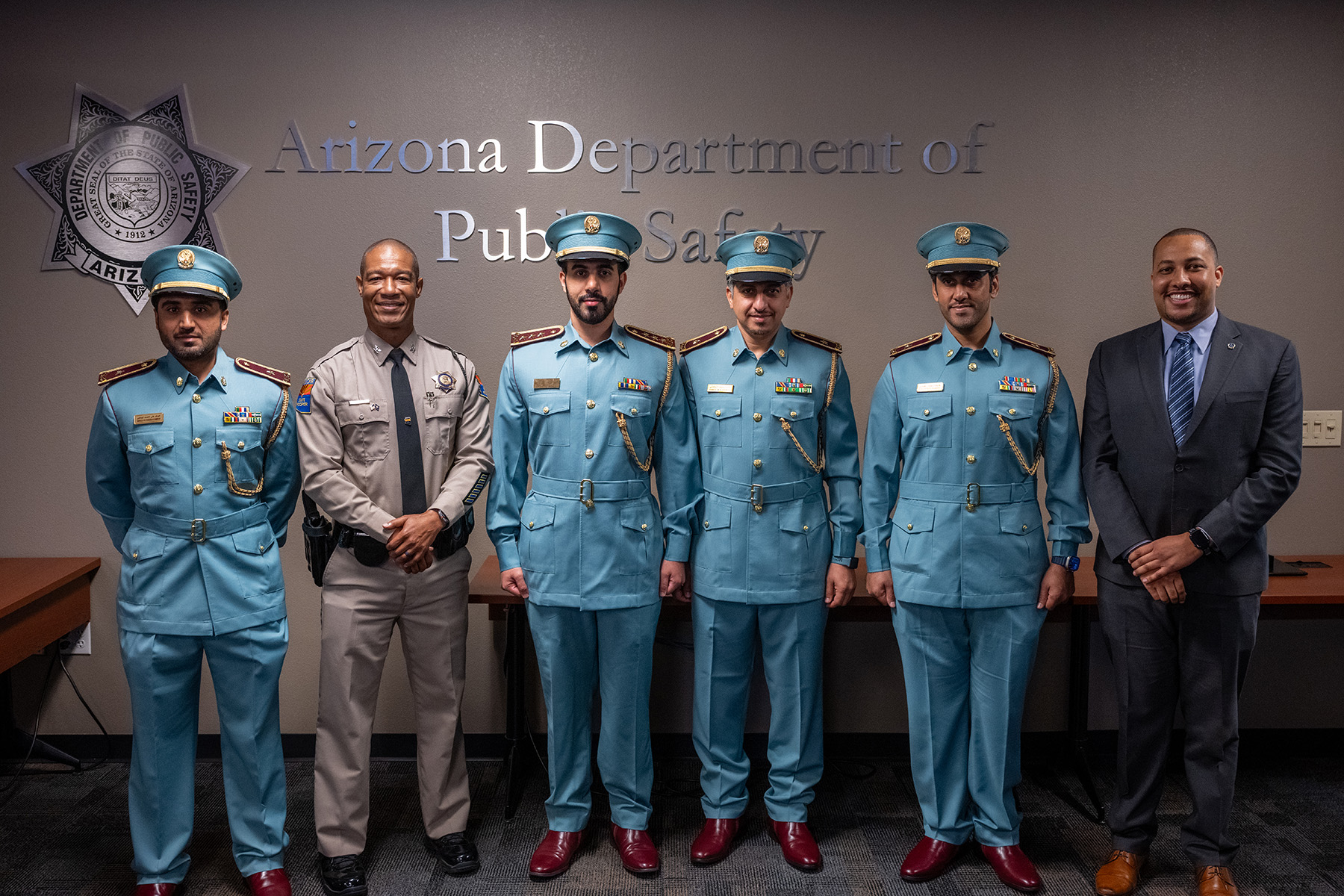 Colonel Glover and Brandon Battle of the IACP pose for a photo with Officer Alhefeiti, Officer Alshehhi, and Officer Alyammahi, as well as Captain Mohamed Alhmoudi during the promotion ceremony.  