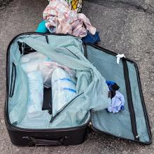 An open luggage bag filled with suspected fentanyl pills in plastic bags