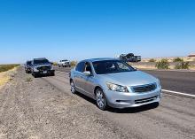 Honda sedan stopped beside freeway with police vehicles behind it