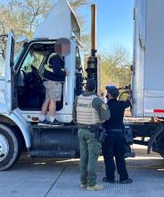 Inspectors looking at truck with driver