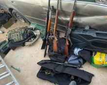 Firearms displayed beside a vehicle