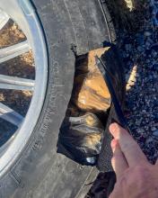 Plastic wrapped bundles are visible in a spare tire that's been cut open