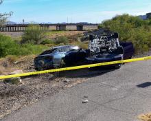 Photo of crash scene showing one overturned vehicle and one upright off of a private road