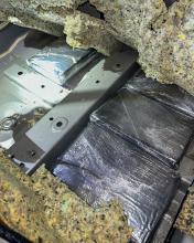 Plastic-wrapped packages of fentanyl powder concealed in a vehicle.