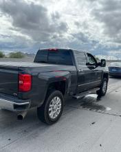 Side view of a gray Chevrolet pickup truck stopped on the shoulder of a highway with AZDPS vehicles around it.