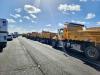 Dump trucks lined up along a highway