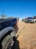 Trooper vehicle with a strap attached to a pickup truck in foreground