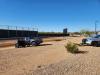 Trooper vehicle with a strap attached to a pickup truck in front of a baseball field