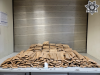 Brown wrapped bundles (of suspected fentanyl pills) are displayed on a table