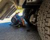 An AZDPS Commercial Vehicle Enforcement trooper underneath a tractor-trailer conducting an inspection