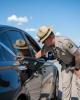 Photo of a uniformed AZDPS state trooper speaking to a driver through their passenger side window