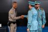 Colonel Glover shakes hands with an ALEAA graduate during the promotion ceremony as Captain Mohamed Alhmoudi looks on.
