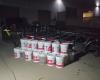 Photograph of 21 five-gallon buckets filled with liquid methamphetamine beside the F350 truck and trailer.