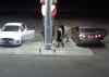 Screenshot from a gas station showing two cars parked at gas pumps. Three males are at the gas pumps.