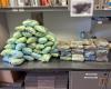 Photo of piles of plastic-wrapped blue pills and bricks of powder seized by troopers are displayed on a counter.